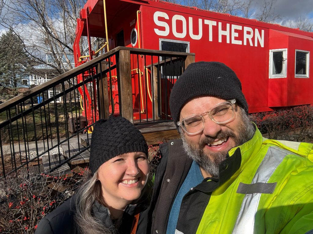 Dianna and Andy in front of a Southern Railroad caboose.